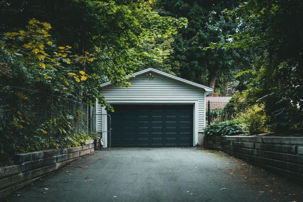 Detached garage with a dark double door on a wooded lot in Stittsville, Ottawa